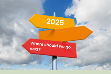 Multicoloured arrow-shaped road signs against a blue cloudy sky. The top sign has the year 2025 on it, and the bottom one reads 'where should we go next?'