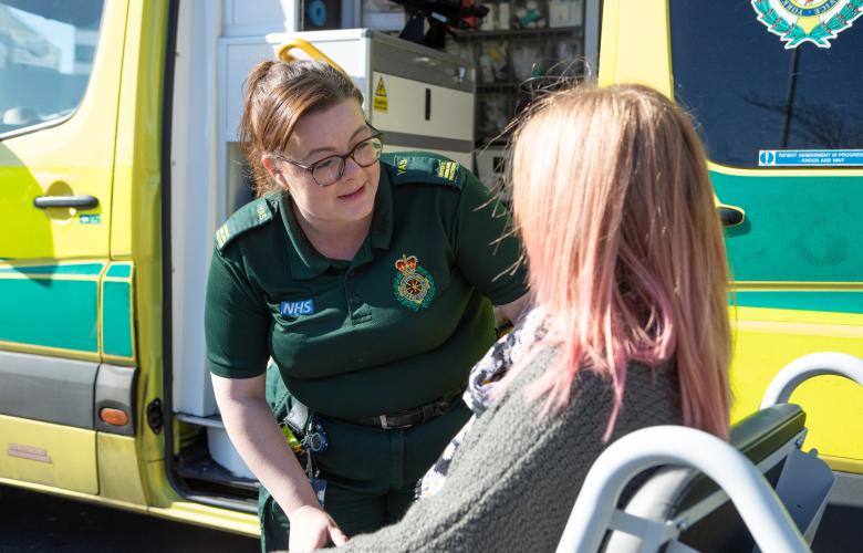 paramedic outside of an ambulance talking to a patient